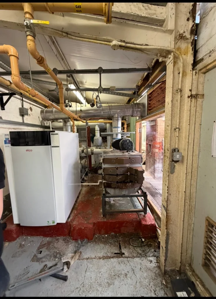 Floor-standing commercial boiler and gas pipework installed in an existing plant room
