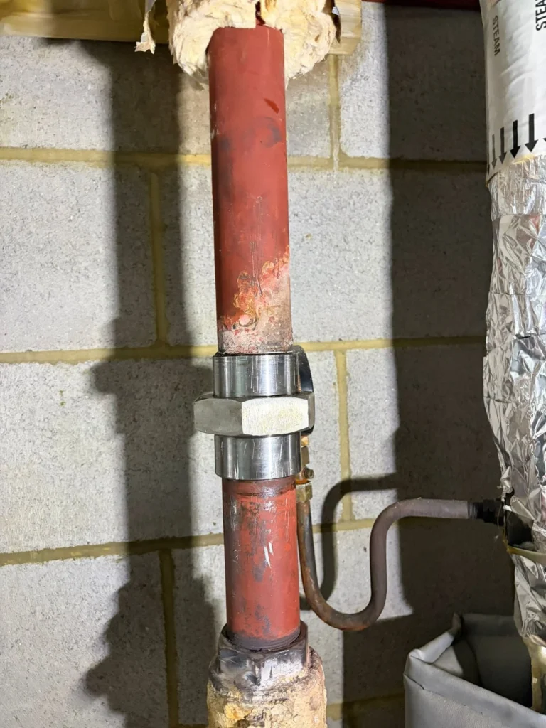 Steel gas riser with union fitting run through blockwork on a commercial gas supply installation
