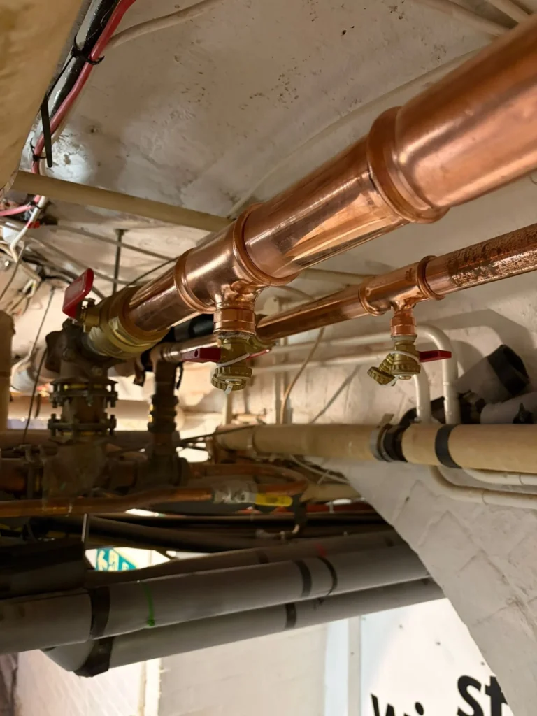 Large-bore copper pipework with isolation and commissioning valves installed at ceiling level