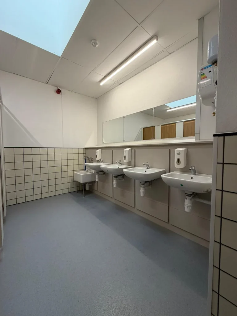 Run of wall-hung basins with concealed services in a completed commercial washroom