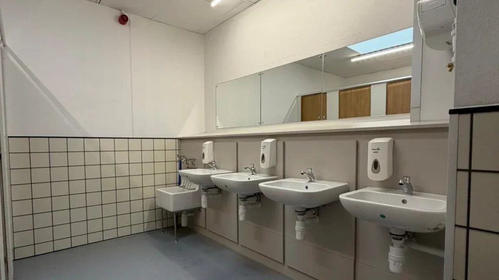Run of wall-hung basins with concealed services in a completed commercial washroom