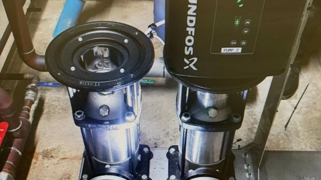 Grundfos vertical multistage booster pumps on a stainless manifold in a commercial plant room