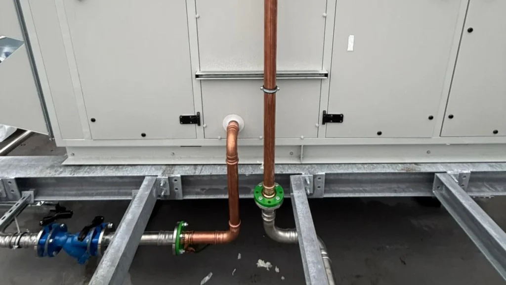 Copper heating pipework and isolation valves connected to a rooftop air handling unit