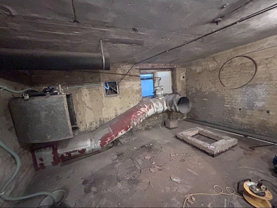 Large diameter warm air distribution ductwork running through a church basement