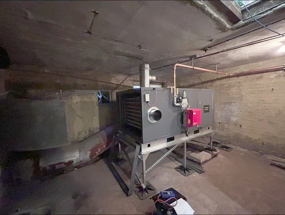 Warm air heating unit connected to distribution ductwork in a church basement