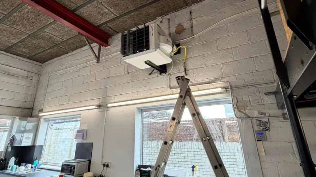Ceiling-mounted warm air heater installed in a commercial workshop