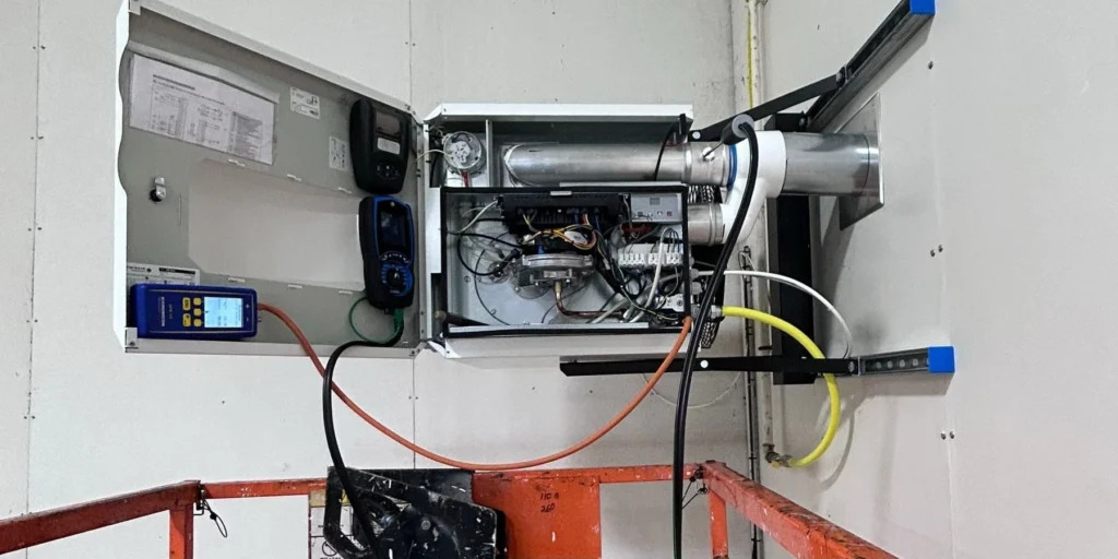 Control panel of a suspended warm air unit heater open during commissioning