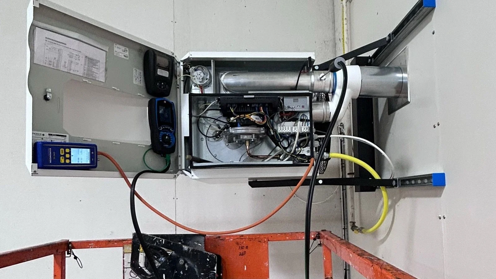 Control panel of a suspended warm air unit heater open during commissioning